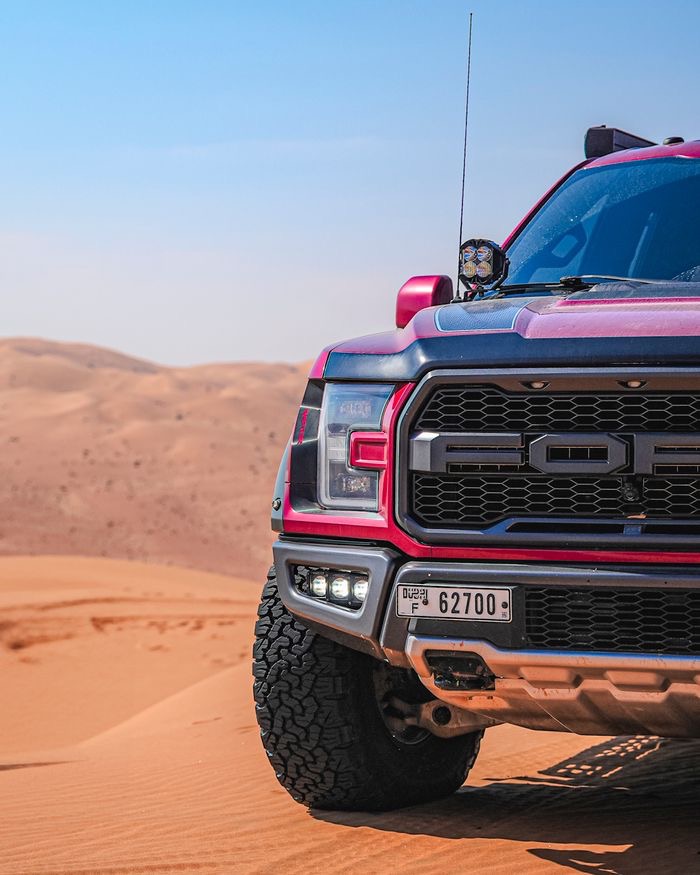 Red off-road truck on desert dunes